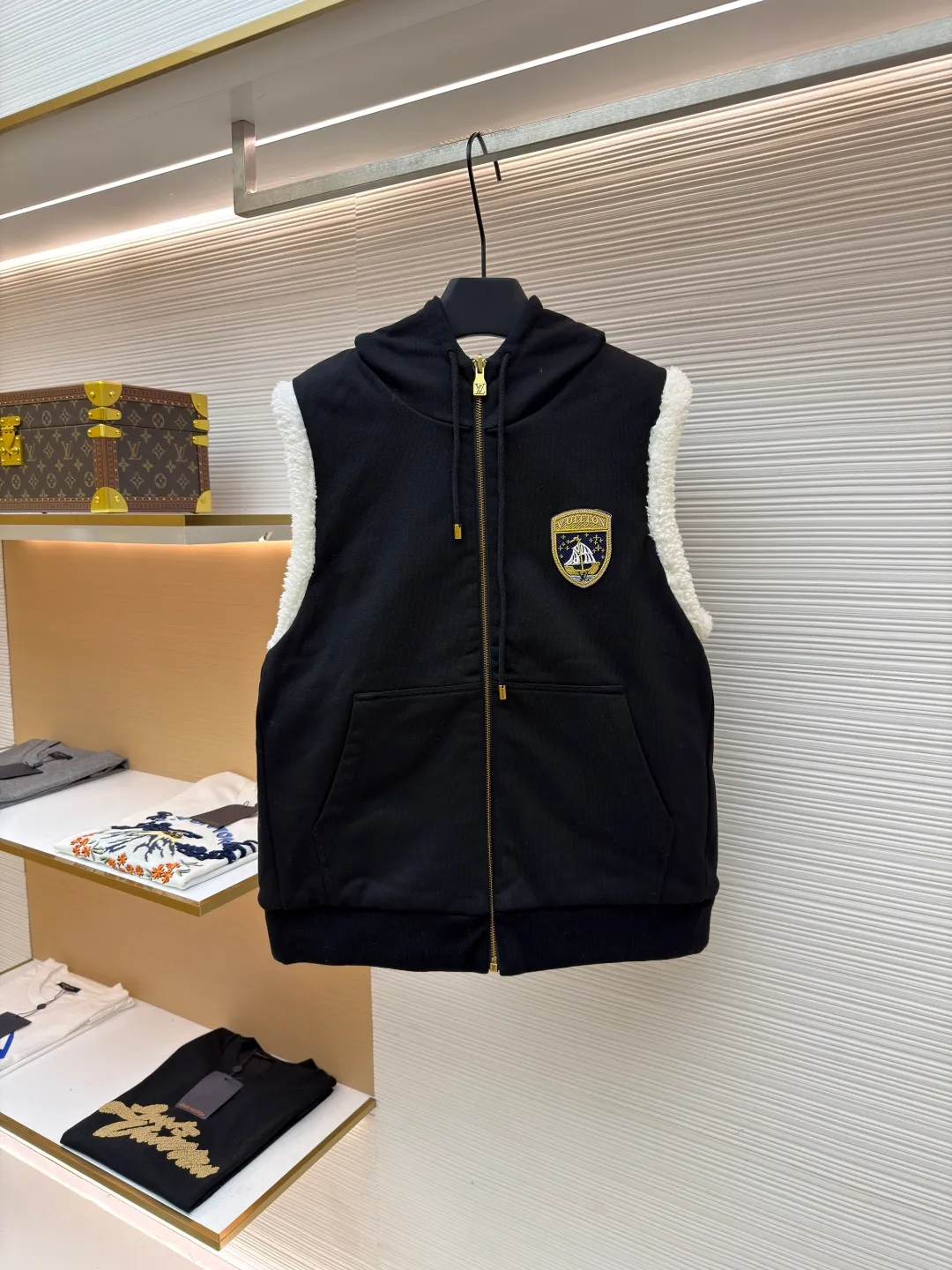 LOUIS VUITTON embroidered reversible hooded vest ●Original version: purchased and developed by 14599 ●Item number: 1681399-C00 ●Fabric: lamb wool fabric ●Technology: embroidery production ●Color: black/white ●Version: fitted version ●Weight: about 1040 grams ●Size: S-M-L-XL ●Description: This vest adopts a double-sided design. One side is made of high-quality knitted fabric, which is crisp, stylish, skin-friendly and comfortable; the other side is made of imitation lamb wool, which is fluffy, soft and has good warmth retention. The hooded part is made of knitted fabric of the same color and is equipped with a two-way zipper with a metal zipper puller, which is smooth and durable. The flip design of cotton knitted surface and comfortable suede surface is very ingenious. It uses advanced double-sided weaving and composite technology to perfectly integrate the two materials and make the transition natural when switching; the shield logo patch uses high-precision patching technology, with neat edges and clear and three-dimensional patterns; the embroidered logo on the back uses fine embroidery technology, with fine and even stitches, and the logo is perfectly integrated into the back design; the drawstring hood uses high-quality drawstrings and precision sewing technology, which not only ensures the adjustment function of the hood, but also enhances the overall sense of leisure. The overall wiring is straight and delicate, the fabric is comfortable and soft, and the color is consistent without color difference. It can be matched with the same style to create a fashionable look and control various occasions. Customized accessories, complete with three standards, same style for men and women!